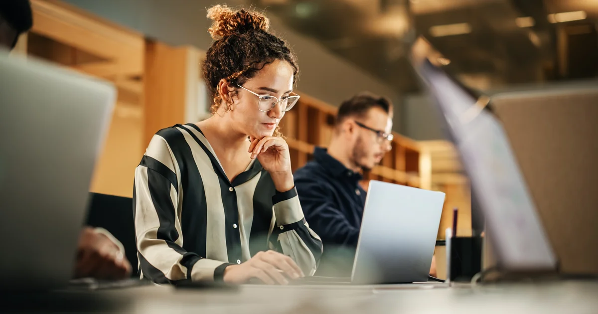 Profesionales trabajando con portátiles en una oficina, el tipo de tarea diaria que ahora pueden asumir modelos baratos como Claude Haiku 5.5