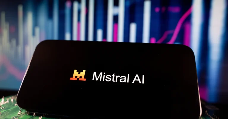 El logo de Mistral AI en la pantalla de un móvil delante de gráficos de mercado, el día que Mistral presenta su modelo Large 4