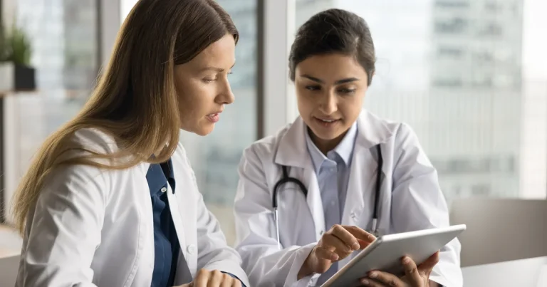 Dos médicas revisan datos de un paciente en una tableta, el tipo de acceso a historiales que dejaba al descubierto el fallo de MyChart